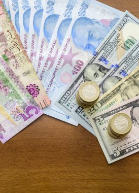 Hesap makinesi, kağıt para ve paralar ahşap bir masada..