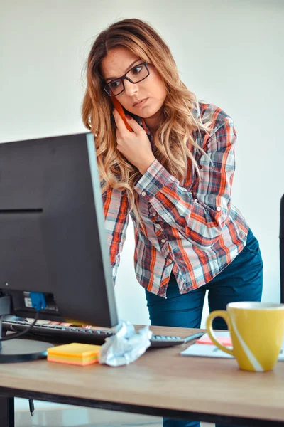 O femeie creativa vorbeste la telefon in timp ce sta la birou — Fotografie, imagine de stoc