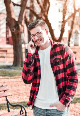 Açık park içinde hareket eden telefon ile modern genç adam portresi