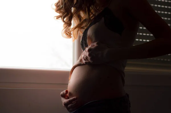 Hermosa joven embarazada cogida de la mano sobre su vientre —  Fotos de Stock