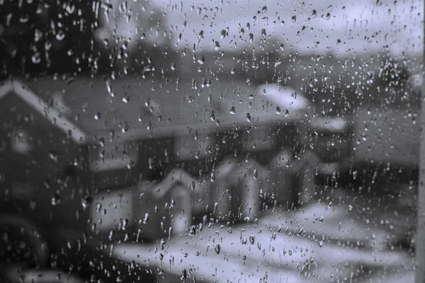 Gocce di pioggia su uno sfondo di vetro drammatico nero. Pioggia in città. Immagine concetto di depressione autunnale — Foto Stock