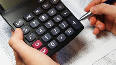 Bir sürü rakamlı hesap makinesi, kalem ve muhasebe belgesi 