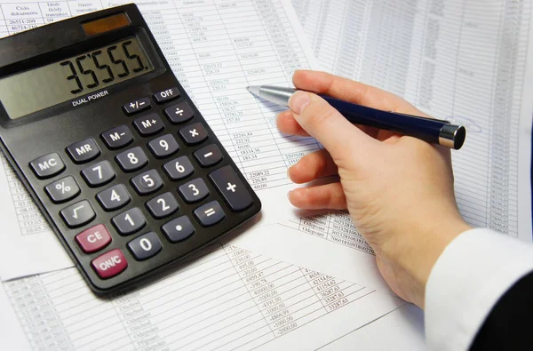 Calculator, pen and accounting document with a lot of numbers and woman hands