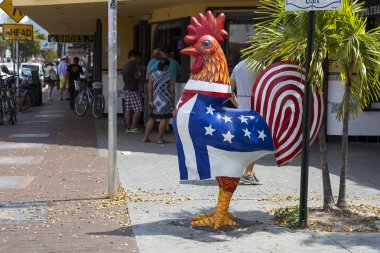 Miami, ABD, 03/18/2016, küçük Havana'da. Horoz. Çiçekler küçük Havana'da Küba ve Amerikan bayrağı ile sembolik horoz heykel.