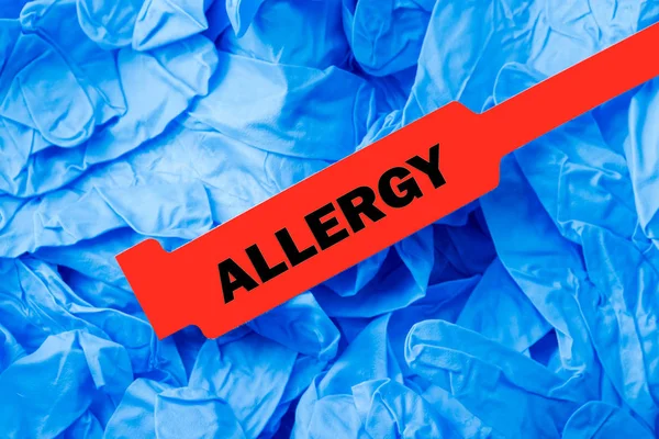 Červená alergie náramek s modré ochranné rukavice — Stock fotografie