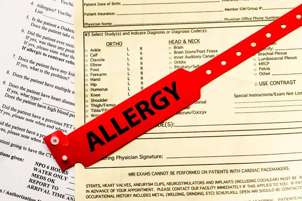 Pulsera de alergia sobre papeleo del hospital Imagen de stock