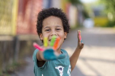 Güzel, mutlu, boyalı elleri olan çocuk.