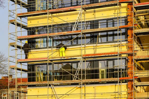 Byggnadsställningar runt huset för att installera värmeisolering av lägenhetsbyggnadens fasad — Stockfoto
