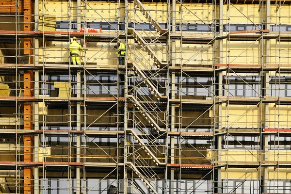 Byggnadsställningar runt huset för att installera värmeisolering av lägenhetsbyggnadens fasad — Stockfoto