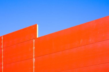 Yeni metal çerçeve binasının duvarı, kırmızı ve gri panellerle kaplı.