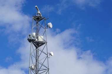 Mavi bir arka planda deniz kenarında yüksek bir navigasyon ve iletişim kulesi.