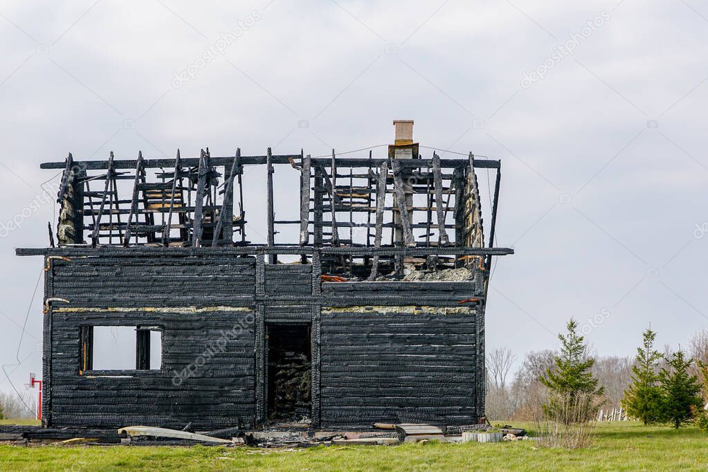 landscape with burnt down two storey wooden house in rural area