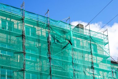 Apartman binasının dış cephesinde yeşil güvenlik ağı