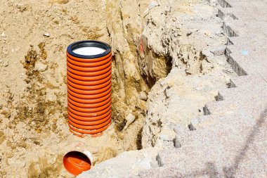 Şehir caddesindeki iletişimin değiştirilmesi, kum çukurundaki turuncu plastik borunun dikey sonu