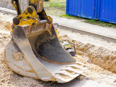 Kazılmış bir siperin yakınındaki inşaat sahasında büyük bir kazı kovası.