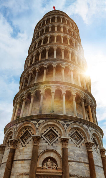 Leaning tower of Pisa with blue sky and sun flare and haze