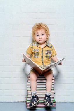 yürümeye başlayan çocuk bir kitapla