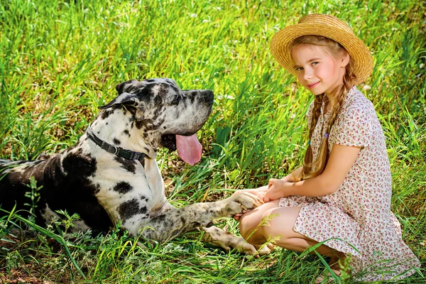 girl holds her dog paw