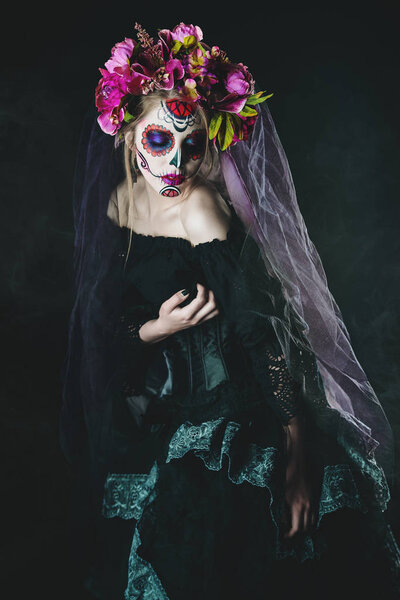 Calavera Catrina in black dress over dark background. Sugar skull makeup. Dia de los muertos. Day of The Dead. Halloween.