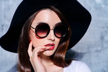 şapka ve yuvarlak güneş gözlüğü