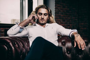 Cep telefonundan konuşuyor.