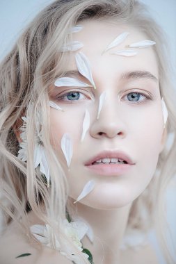 Yüz ve vücut üzerinde krizantem yaprakları olan güzel kadın. Güzellik, doğal kozmetik kavramı.