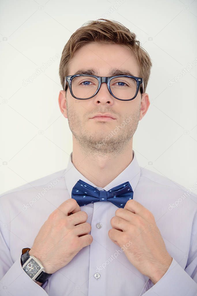 Men's beauty, fashion. Well-groomed young man wearing elegant suit and bow-tie.