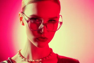 Gözlük takan kendine güvenen bir kadının yakın portresi. Güzellik, makyaj, tarz.