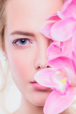 Yakın çekim portre çiçekler ile güzel bir romantik genç kadının. Beyaz arka plan. Kozmetik, sağlık. Güzellik, moda kavramı.