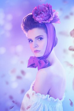 Nazik romantik bir kızın portresi zarif başlıklı, şakayık çiçekli, mor, çiçek yapraklı. Baharın ilhamı. Güzellik, moda.
