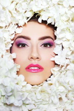 Pembe ve mor güneş gözlüklü ve yüzünde beyaz çiçeklerle güzel bir kızın yakın plan portresi. Baharın ilhamı. Güzellik ve kozmetik.