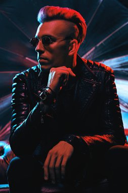 Kırmızı ışıkta deri ceketli bir disko çocuğunun portresi. Parti, disko. Renkli ışık.