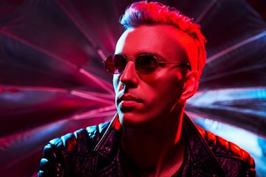 Kırmızı ışıktaki yakışıklı bir disko adamının portresi parti, disko. Renkli ışık.