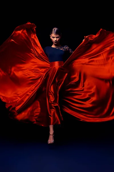 Beautiful girl professional dancer performs latino dance. Passion and expression. Black background.