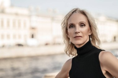 Nehir kenarındaki zarif, yaşlı bir kadının portresi. Güzellik, moda.