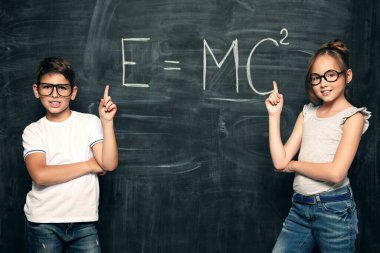 Bir sınıfta ki tahtanın üzerinde iki neşeli genç öğrencinin portresi. Güzellik, moda, okul, eğitim.