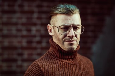 Duvarın arkasında gözlüklü yakışıklı bir adam. Optik biçimi. 