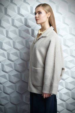 Bahar ve sonbahar giysileri moda. Güzel sarışın kız stüdyoda ceketle poz veriyor.. 