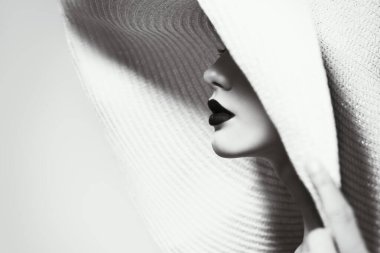 Zarif yaz şapkalı muhteşem bir genç kadının siyah beyaz portresi. Moda çekimi, güzellik..