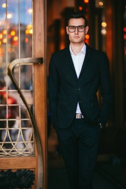 Sokakta yürüyen yakışıklı bir gencin portresi. Resmi erkek modası.