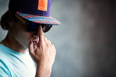 Kapalı poz veren şapkalı genç, yakışıklı bir adamın portresi. Rahat erkek moda, güzellik, optik.