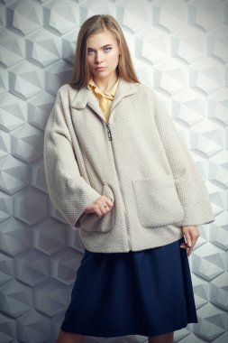 Bahar ve sonbahar giysileri moda. Güzel sarışın kız stüdyoda ceketle poz veriyor.. 