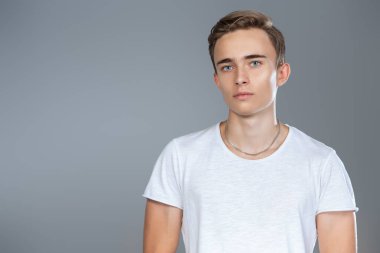 Beyaz tişörtlü genç, yakışıklı bir adamın portresi. Erkeklerin güzelliği, gündelik moda.