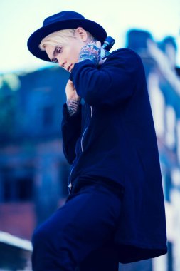 Sokakta yürüyen, açık saçlı genç bir adamın portresi. Gündelik moda, güzellik.