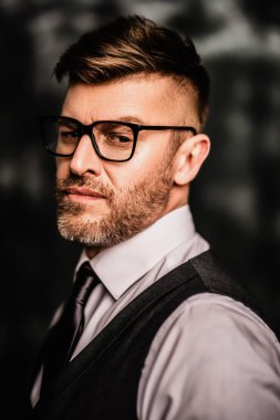 Stüdyoya poz veren yakışıklı acımasız olgun bir adamın portresi. Gündelik resmi moda, erkek güzelliği.