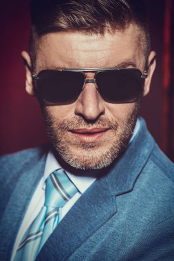 Bir yakından bardaklarda acımasız bir yakışıklı adam portresi. Erkek güzelliği, moda. Erkekler için optik.