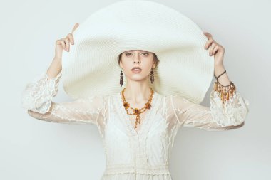 Zarif dantel elbisesi ve geniş kenarlı şapkası olan güzel bir bayan. Moda fotoğrafı, yaz tarzı..