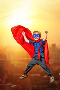 Süper kahraman kostümüyle uçan komik bir gencin uzun bir portresi. Çocuk gelişimi ve eğitim kavramı.