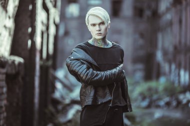 Sokakta yürüyen, açık saçlı genç bir adamın portresi. Gündelik moda, güzellik.