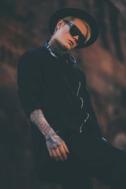 Harabelere karşı poz veren sarışın bir gencin portresi. Sıradan moda, güzellik..